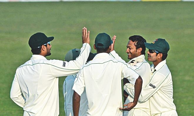 Shakib Al Hasan (2nd from R) is congratulated by teammates as his late double-strike brought smile to the Bangladesh camp at the end of the first day of the second Test against Sri Lanka at the Zahur Ahmed Chowdhury Stadium in Chittagong yesterday.  PHOTO: ANURUP KANTI DAS