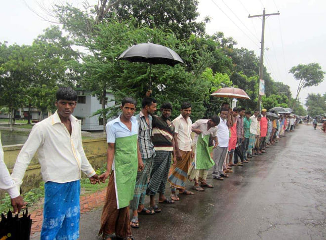 Framers of Nizampur in Kalapara upazila under Patuakhali district form a human chain at the upazila headquarters yesterday demanding immediate steps to repair the broken embankment in their area to save farmlands from flooding by saline water. PHOTO: STAR