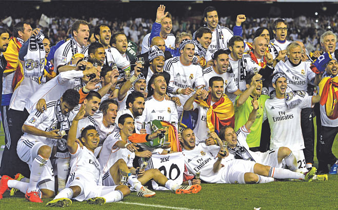 Real Madrid players celebrate with Copa del Rey trophy, their first of the season, on the pitch at the end of the match. Photo: AFP