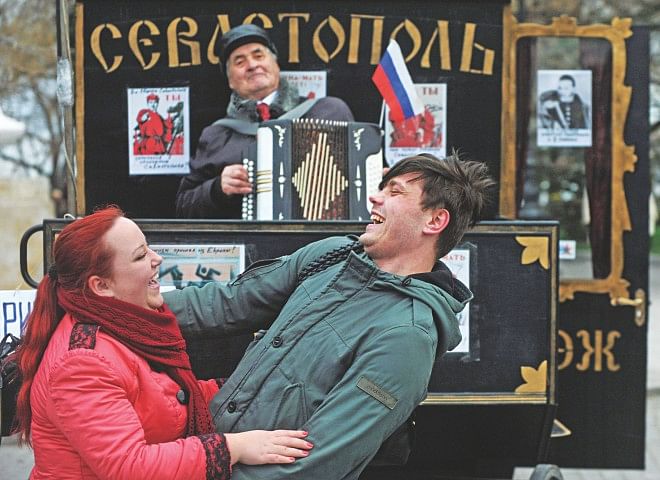 A man plays accordion as people dance during celebrations in Sevastopol yesterday. Crimea applied to join Russia after the flashpoint peninsula voted to leave Ukraine in a ballot that has fanned the worst East-West tensions since the Cold War. PHOTO: AFP