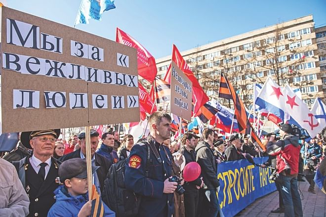 Pro-Kremlin activists hold Russian national, Russian and Soviet naval flags and orange-black flags made of the St George's Ribbons, a well-known Russian symbol of military valor, during a rally in support of ethnic Russians in Ukraine in central Moscow, yesterday. Photo: AFP