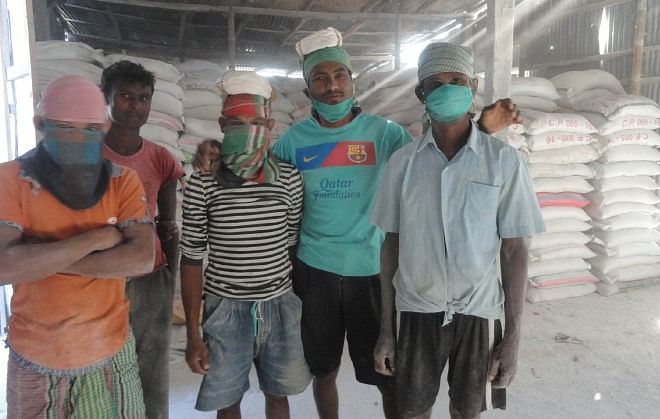 Workers use normal masks instead of professional ones at a limestone crushing factory in Burimari land port area in Patgram upazila of Lamonirhat.  PHOTO: STAR