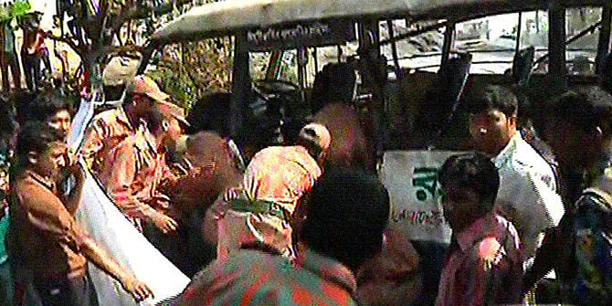 Firefighters rescue passengers of a minibus, which was hit by a train at Chandgaon in Chittagong city Tuesday morning. Four garment workers were killed and 15 workers injured in the accident. Photo: TV grab 
