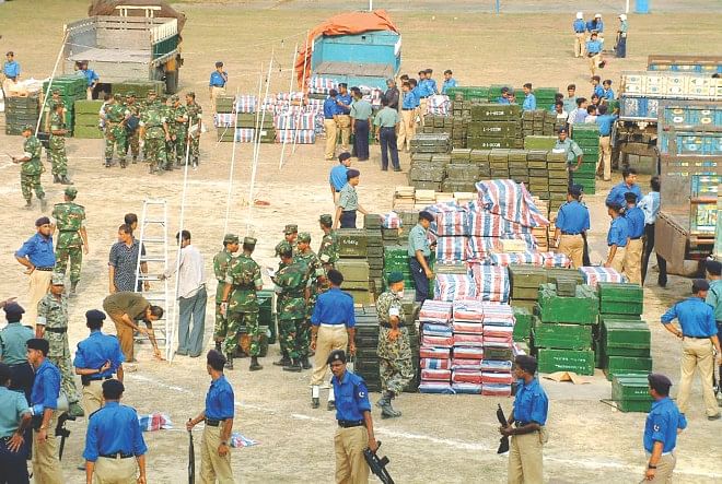 Police, army and BDR personnel sorting out the huge cache of arms and ammunition captured at the Chittagong Urea Fertiliser Ltd. jetty in the early hours of April 2, 2004. Photo: FILE