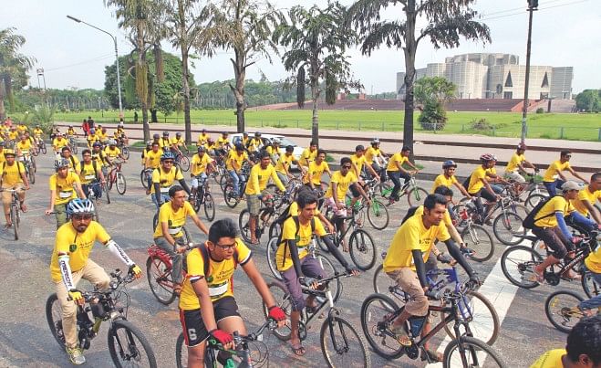 With the slogan "Let's Rebuild Our Nation" emblazoned on their T-shirts, cyclists bring out a procession on Manik Mia Avenue in the capital yesterday. Volunteers for Bangladesh, the volunteer wing of JAAGO Foundation, organised the programme marking World Environment Day. Photo: Palash Khan