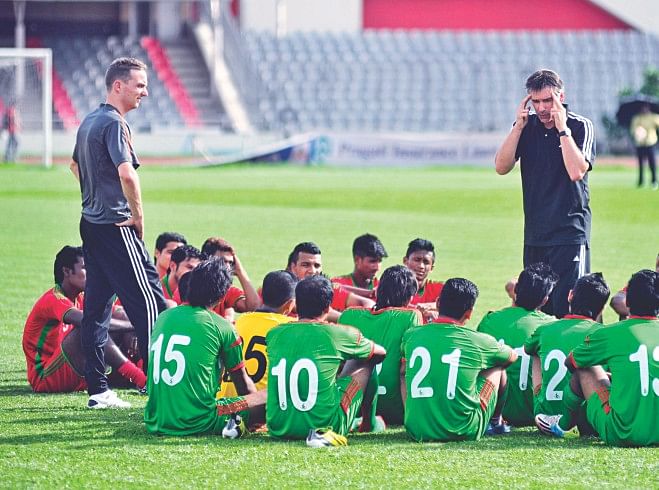 National football team's head coach Lodewijk de Kruif (R) briefs his charges as assistant coach Rene Koster (L) looks on after a practice match between the players at the Bangabandhu National Stadium yesterday. PHOTOS: STAR
