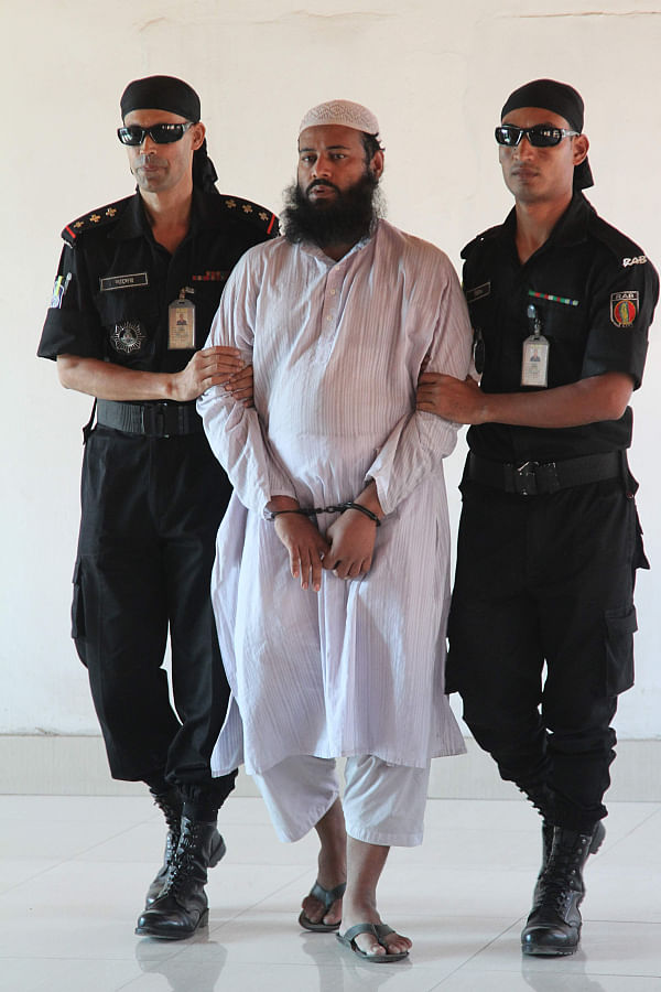 Huji top-notch Abu Bakar Siddique, sentenced to death for Ramna Batamul carnage that killed 10 people in 2001, being escorted to media briefing at the Rab headquarters yesterday. Photo: Sk Enamul Haq