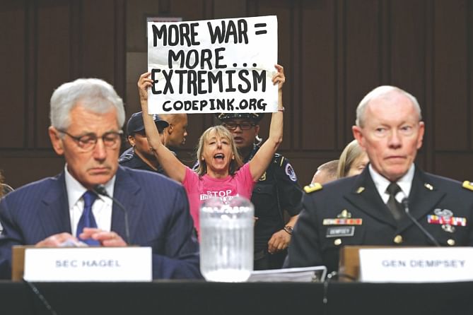 A woman protests against US military action in Iraq as Defense Secretary Chuck Hagel (L) and Chairman of the Joint Chiefs of Staff Army Gen Martin Dempsey testify before the Senate Armed Services Committee in Washington, DC, yesterday.  Photo: AFP