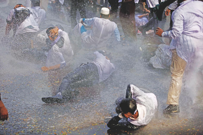 Several students of dental colleges fall to the ground as police use water cannons on them in front of Bangladesh Secretariat yesterday. Photo: Star