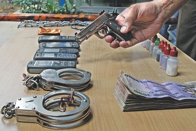 Detective Branch of police shows the handcuffs, drugs, money, phones, and the fake pistol they seized from a gang of five alleged kidnappers on Sunday. The photo was taken from DMP media centre in the capital yesterday. Photo: Star