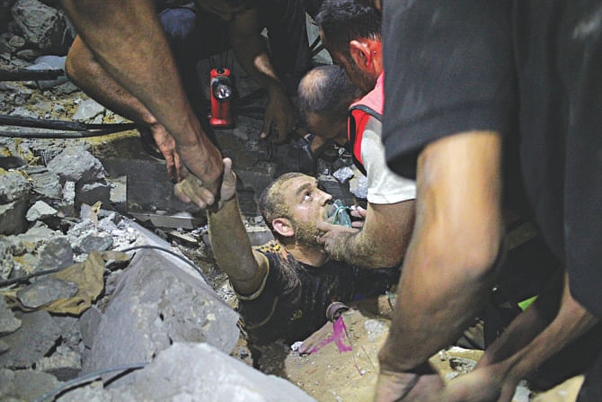 Rescue workers dig out a man from the ruins of an Israeli air strike late on Tuesday night. Israeli intensified air raids on Gaza yesterday as furious mourners buried the wife and child of Hamas's top military commander, baying for revenge as nine days of calm exploded into bloodshed.  Photo: Reuters
