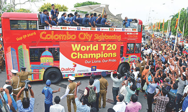 ICC World T20 champions Sri Lanka take a merry ride on an open-top bus as jubilant fans line the Colombo streets to greet their cricketing heroes yesterday. Photo: AFP