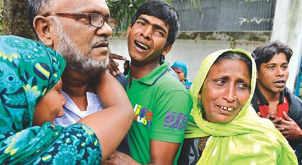 This courtesy file photo shows family members of Musa and Masud huddle together and cry. Musa and his son Masud, supporters of winning Jatiya Party candidate were killed on January 6 when supporters of defeated Awami League election candidate Mannan Khan attacked them at Hajarbigha of Dohar in Dhaka. 