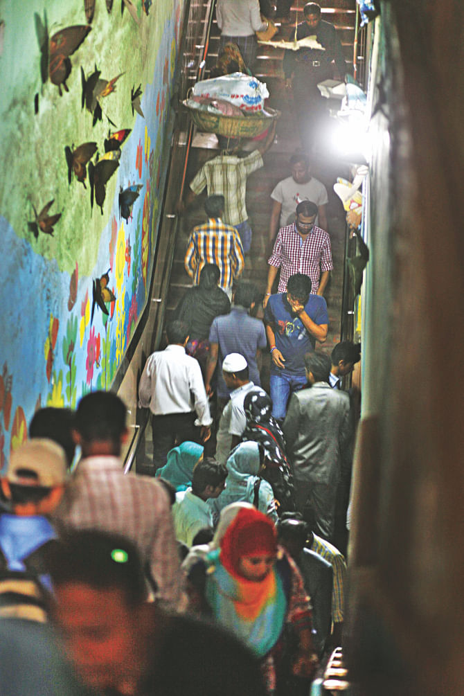 Pedestrians in the poorly lit, stinky and dusty underpass at Karwan Bazar in Dhaka yesterday. Photo: Rashed Shumon/Amran Hossain
