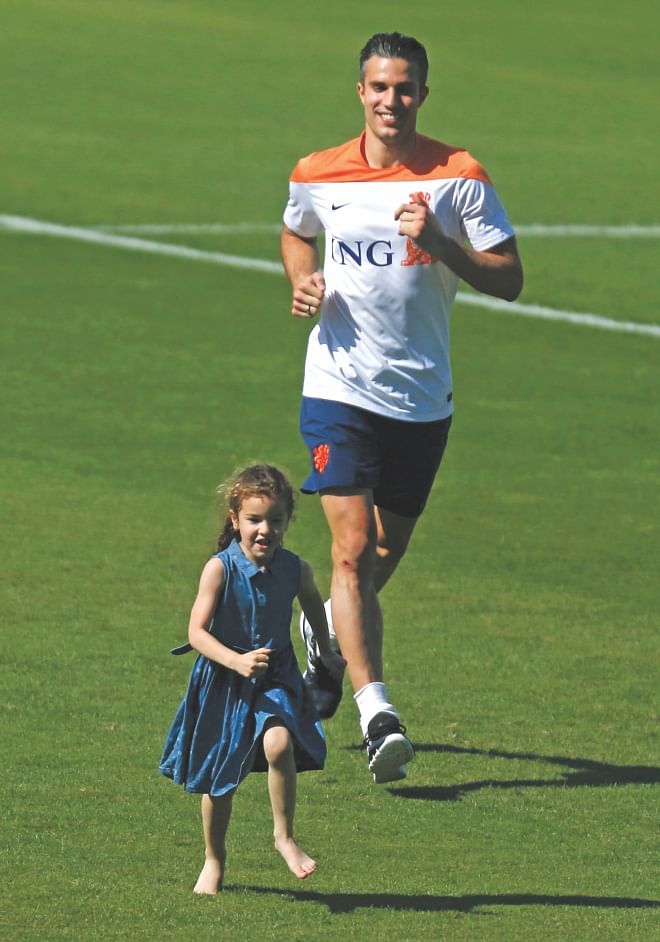 Dutch striker Robin van Persie runs behind his daughter during a training session in Rio de Janeiro. RVP will look to add more to his fantastic double against Spain when his side take on Australia today.  Photo: Reuters 