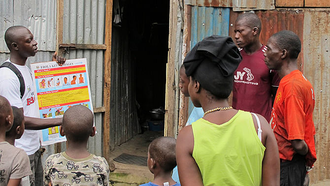 An outreach worker speaks with residents about the information on the symptoms of Ebola virus disease (EVD) and best practices to help prevent its spread, in Freetown, Sierra Leone in this August, 2014 handout photo provided by Unicef August 6. Photo: Reuters 