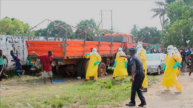 Health workers surround an Ebola patient who escaped from quarantine from Monrovia's Elwa hospital, in the centre of Paynesville in this still image taken from a September 1, 2014 video. The photo is taken from Reuters. 