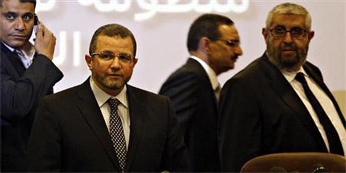 Egypt's Prime Minister Hisham Kandil (2nd L) is seen with Sherif Haddara (R), Minister of Petroleum at news conference about a new "smart card" system to tracj purchases of subsidized fuel which will start next month, at General Petroleum Corporation headquarters in Cairo June 22. 