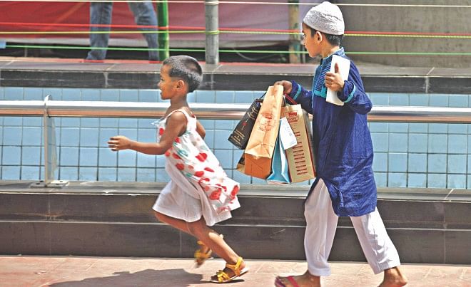 Two ecstatic kids with their Eid clothes in front of the capital's Bashundhara City yesterday. Photo: Star