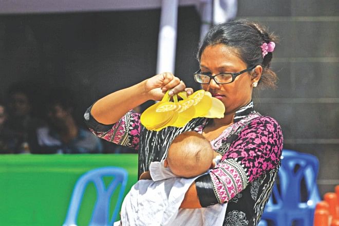 A new mom, who could not hold back the temptation of shopping, takes care of her infant outside the mall.  Photo: Star