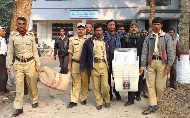 Polling officials with the help of law enforcers take election materials, including ballot papers and ballot boxes, to the polling centres in Kaharol upazila of Dinajpur district yesterday. The upazila goes to polls today. Photo: Star