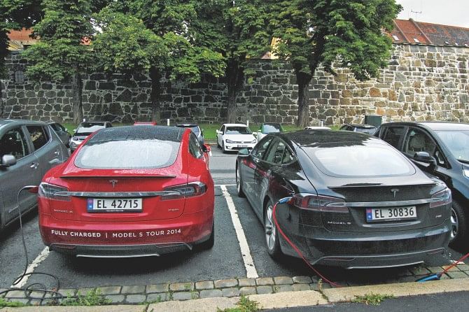Cars are seen charging in free parking spaces for electric cars in Oslo. Despite being one of the world's largest oil producers, Norway's electric car fleet grows at such pace that the authorities are pondering an incentive cut. Photo: AFP 