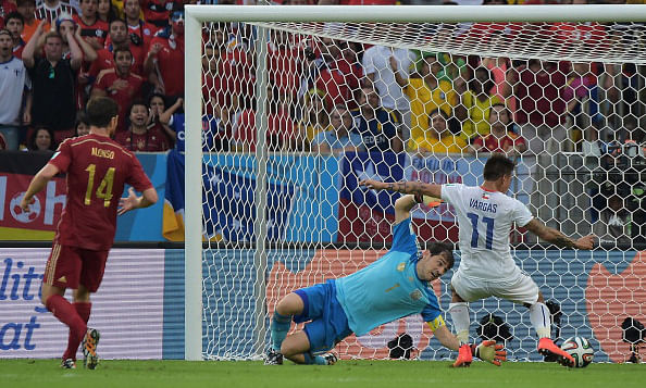 Chile's forward Eduardo Vargas (R) strikes to score Chile's first goal as Spain's goalkeeper and captain Iker Casillas (C) defends and Spain's midfielder Xabi Alonso watches on during a Group B football match between Spain and Chile in the Maracana Stadium in Rio de Janeiro during the 2014 FIFA World Cup on June 19, 2014. Photo: AFP/Getty Images