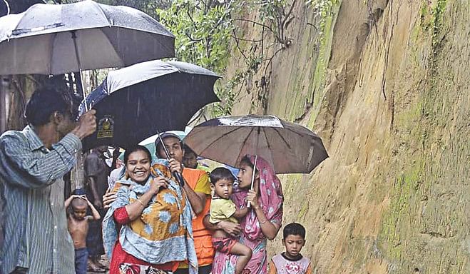 Hill slope residents vulnerable to mudslides during the monsoon in Chittagong city being evacuated by the district administration and law enforcers at Lalkhan Bazar during an eviction drive yesterday. They are being temporarily relocated to a makeshift shelter at Tiger Pass Government Primary School. Photo: Anurup Kanti Das