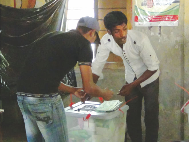 People identified as supporters of AL-backed chairman candidate Mosharraf Hossain cast fake votes at West Bapta Govt Primary School polling station in Bhola yesterday morning. Photo: Star