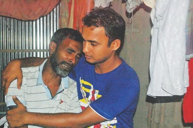 A relative consoles the brother of Elahi Hossain, 31, of the same district, as the two men along with Faruk Khan, 38, of Munshiganj were killed Monday in a construction site collapse in Malaysia where they went in hope of bettering their lives. Photo: Star