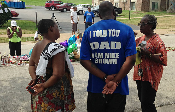 Michael Brown Sr talks with well-wishers on August 22 at a makeshift memorial set up to honor his son, Michael, who was fatally shot by a white police officer 13 days ago in Ferguson, Missouri. Photo: Reuters 