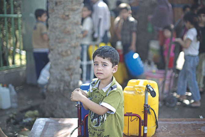 A Palestinian child waits to fill plastic bottles and water containers with drinking water from a public tap in Jabalia in the northern Gaza Strip yesterday during a short-lived truce agreed between the warring parties. Israeli military yesterday resumed its assault on Gaza after Hamas shunned an extended lull accepted by Israel, medics said. Photo: AFP