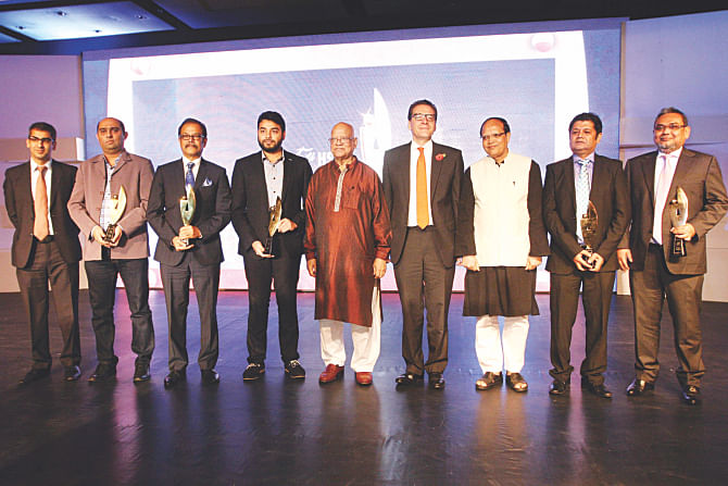 Finance Minister AMA Muhith, Bangladesh Bank Governor Atiur Rahman, and HSBC Bangladesh Chief Executive Francois de Maricourt pose with exporters awarded by HSBC for their excellence in business, at Radisson Hotel in Dhaka on Friday. Photo: Star