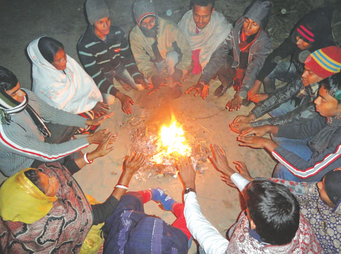 While people gather around a fire in Roypara of Lalmonirhat for warmth. Photo: Anisur Rahman\Star
