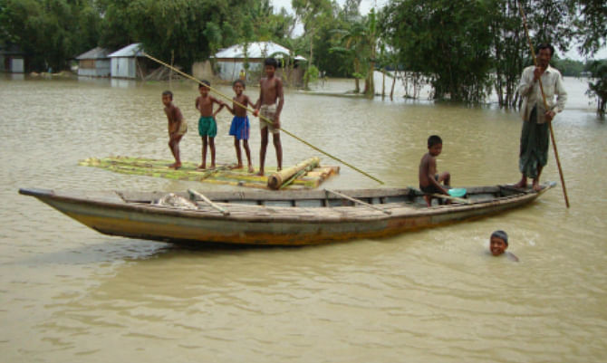 A man and some kids row a boat and a raft in flood-hit Sindurna village under Hatibandha of Lalmonirhat. Photo: Star