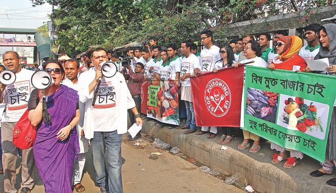 Volunteers chant slogans against food adulteration using megaphones during a human chain organised by a community group in front of the capital's Jatiya Press Club yesterday. The group arranged the programme demanding strict enforcement of food safety laws. Photo: Star