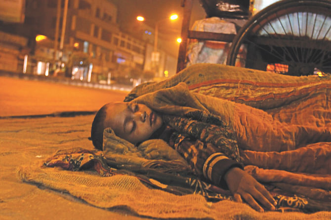 A child sleeps on the footpath of Kazi Nazrul Islam Avenue at Karwan Bazar in the wee hours of yesterday. Photo: Anisur Rahman\Star