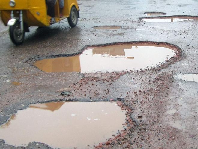 Such potholes appearing in a large portion of Barisal-Dhaka highway in Barisal district during the ongoing monsoon make vehicular movement a tough job. The photo was taken from near Gournadi upazila headquarters in the district.   PHOTO: STAR
