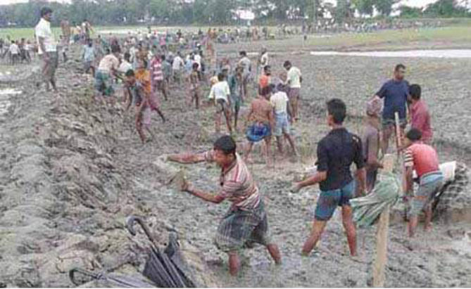 Locals render voluntary service to repair the breached portion of the embankment at Char Mohiuddin village in Char Biswas union of Galachipa upazila under Patuakhali district to save their farmlands from saline water. PHOTO: STAR
