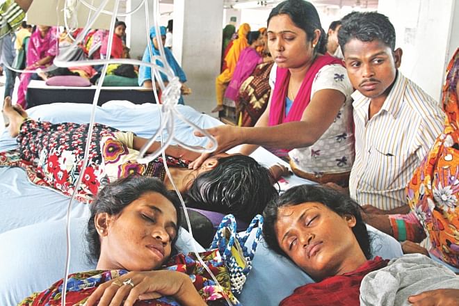 Hooked up to a saline drip, the garment workers of Tuba Group on their fourth day of hunger strike yesterday inside their factory in Badda of Dhaka. They have been demanding three months' arrears and Eid bonuses.  Photo: Amran Hossain