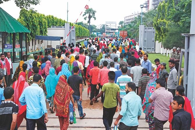 Garment workers of a factory in Ashulia report to duty as usual yesterday, defying a strike called by Tuba Group Sramik Sangram Committee, a temporary platform of 15 trade unions. Photo: Star