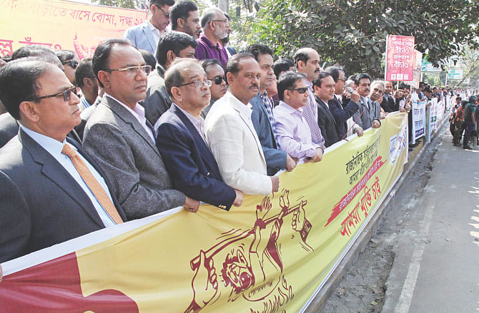 Garment exporters participate in a demonstration in front of the BGMEA headquarters in Dhaka yesterday, demanding an end to the drawn-out political impasse that unsettled the business environment. Photo: Star