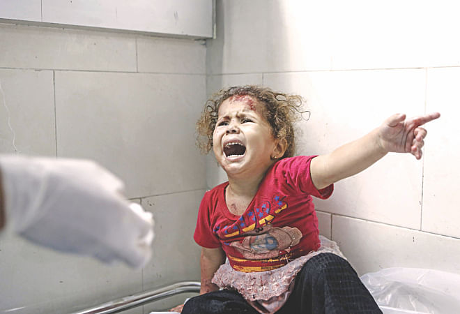 A Palestinian child cries out at al-Shifa hospital after Israeli forces shelled her house in Gaza City yesterday. Gaza hospitals are being filled with increasing number of injured -- many of whom are children -- as the Israeli onslaught continues.  Photo: AFP