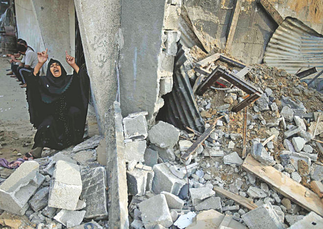 A Palestinian woman reacts next to the rubble of her relatives' house, which police said was destroyed in an Israeli air strike, in Khan Younis in the southern Gaza Strip yesterday. Israeli tanks shelled militant targets and a woman died in an air strike after the bloodiest day of a nearly two-week military offensive that showed no signs of abating, despite global calls for a truce. Photo: Reuters 