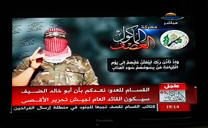 Abu Ubaida, the spokesman of the Izz el-Deen al-Qassam Brigade, the armed wing of the Hamas movement, is pictured on a television screen as he delivers a televised statement on Hamas TV, in Gaza August 20. Photo: Reuters 