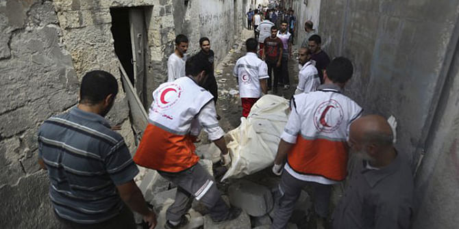 Palestinian medics carry a dead body found under the rubble of a home destroyed by an Israeli strike in the Shijaiyah neighbourhood of Gaza City, northern Gaza Strip, July 20. Photo: AP