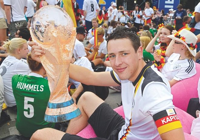A German fan holds a mock World Cup trophy at a public viewing event in Berlin yesterday, ahead of his national team's mouth-watering World Cup final against Argentina in Rio de Janeiro. Photo: Reuters