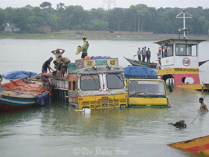 An over-loaded ferry carrying seven goods-laden trucks capsizes in Madhumati river near the pontoon of Kalna ferry ghat at Kashiani upazila of Gopalganj on Thursday.