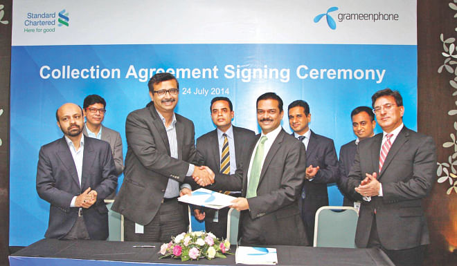 Vivek Sood, chief executive officer of Grameenphone, and Abrar A Anwar, acting chief executive of Standard Chartered Bangladesh, attend the signing of an agreement at a programme in Dhaka yesterday. The bank will collect the mobile operator's sales proceeds from across the country.  Photo: StanChart