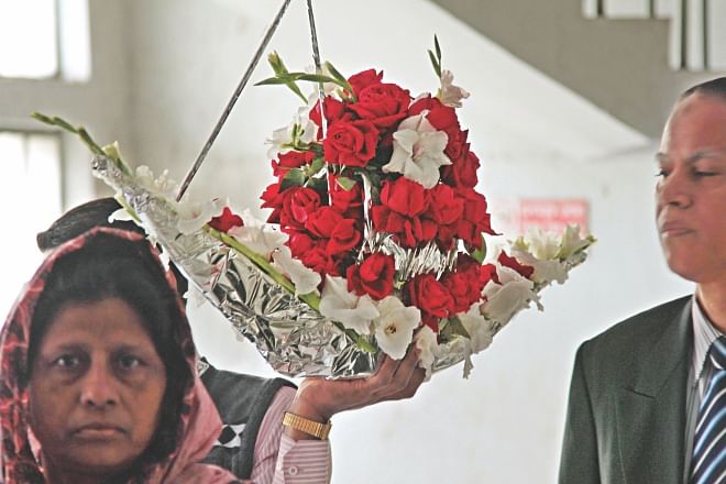 A man carries a flower bouquet shaped like a boat, the election symbol of ruling Awami League, to greet a minister at the secretariat yesterday.  Photo: Sk Enamul Haq